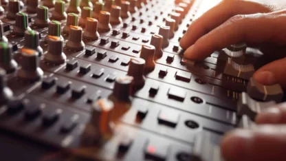 Engineer's hands working at an audio mixer.