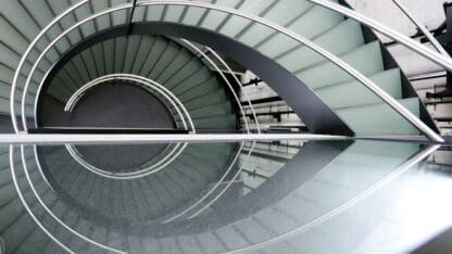 Looking down the span of a circular staircase and its reflection.