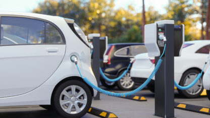 An electric car parked at and using a charging station.