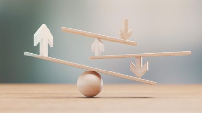 Wooden sculptures of arrows, lines, and a sphere placed on each other to illustrate balance.