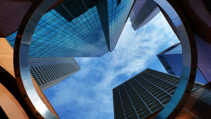 Skyward perspective of skyscrapers through circular structure.
