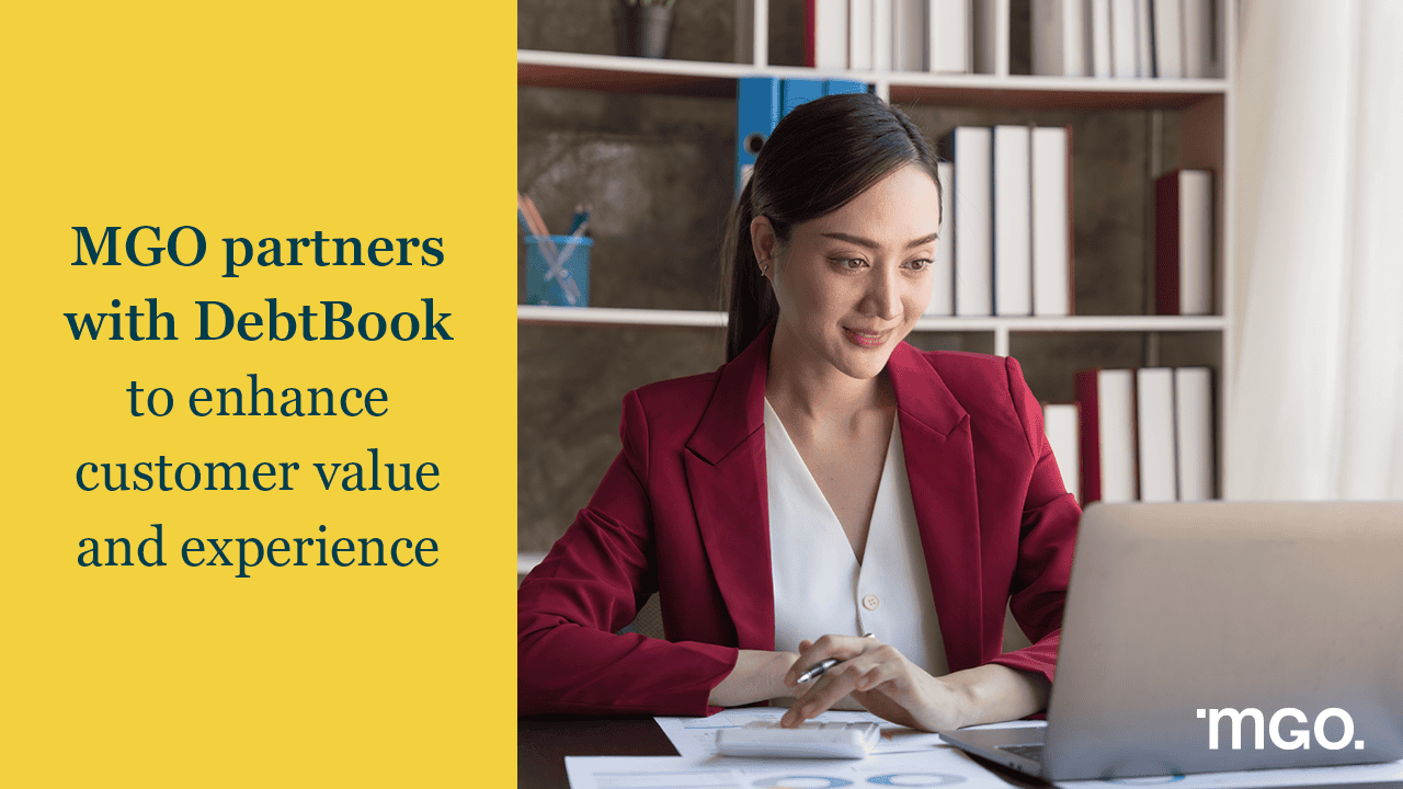 Banner announcing a partnership between MGO and DebtBook next to an image of a woman working a calculator next to her laptop.