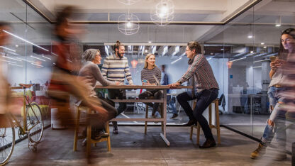 A tabletop meeting capturing the blurred motion of people passing by.