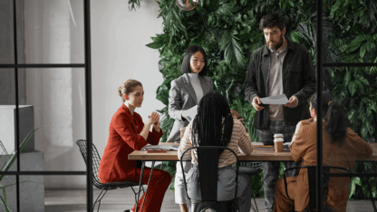 Image of diverse group of business people meeting at table in modern office