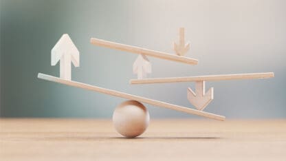 A number of arrows, lines, and a sphere made out of wood and arranged in a display to show the concept of balance.