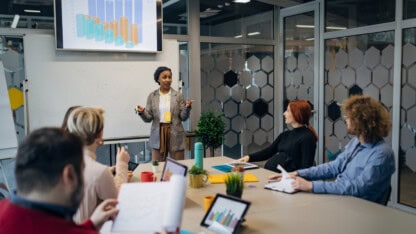 Professionals sharing data analytics in conference room, providing visibility to detect patterns for cybersecurity