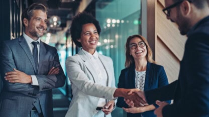 Group of businesspeople meeting sharing hands over an M&A deal