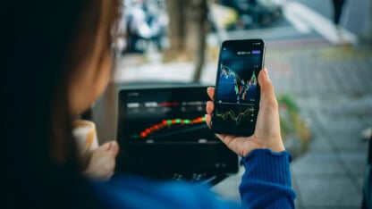 A young woman uses a smartphone app to manage personal finance and investments