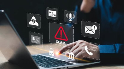 Person using a laptop surrounded by icons of scams and cybersecurity threats, with a “SCAM” warning displayed.