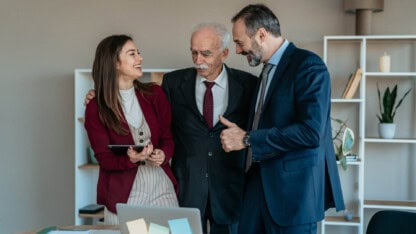 Three people having a group meeting in a conference room.