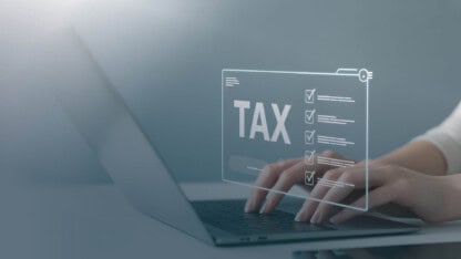 Hands typing on computer, sorting out taxable and nontaxable compensation
